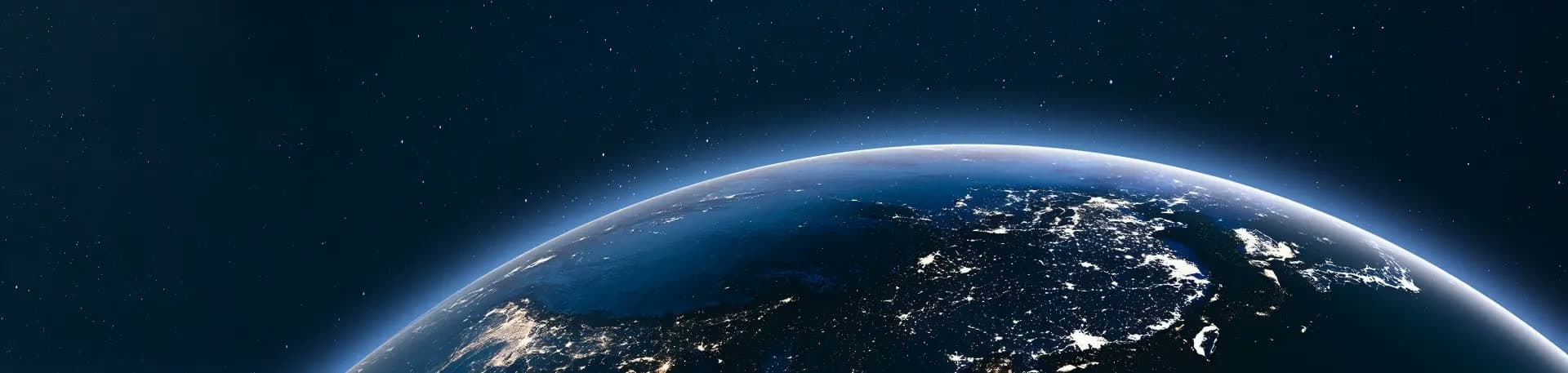 Earth seen from space at night, city lights glowing across continents