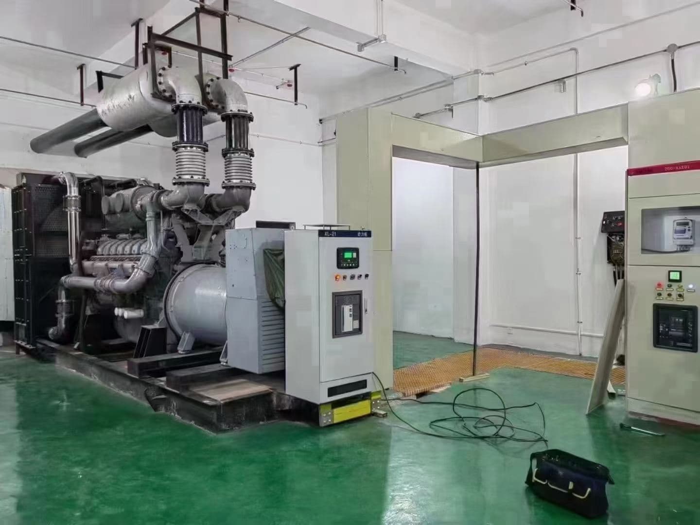 A 500 kW set in a finished machine room with a green epoxy floor, overhead exhaust and switchgear cabinets alongside