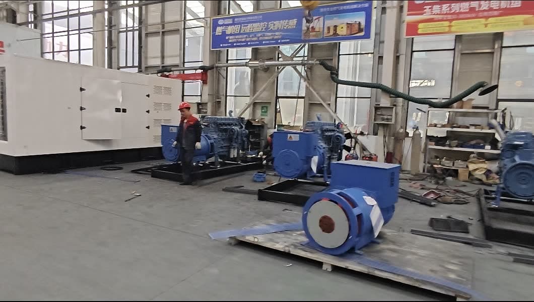 Engines and alternators being mounted on base frames across the assembly floor