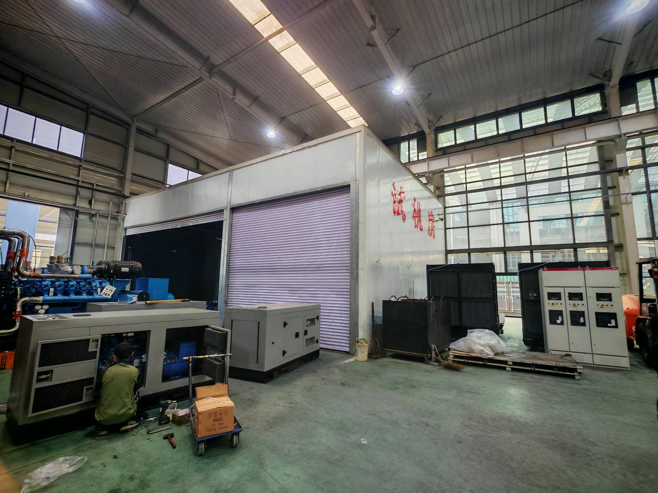 Test cell with control cabinets and a worker inside an open canopy